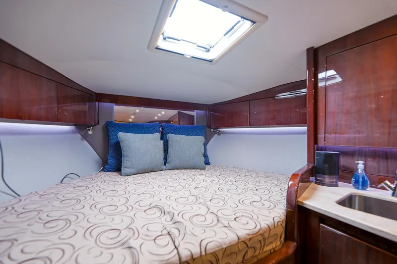 Tranquila Yacht Photos Pics Luxurious cabin interior of 2016 Jupiter 41 EX yacht with cozy bed and wooden cabinetry.
