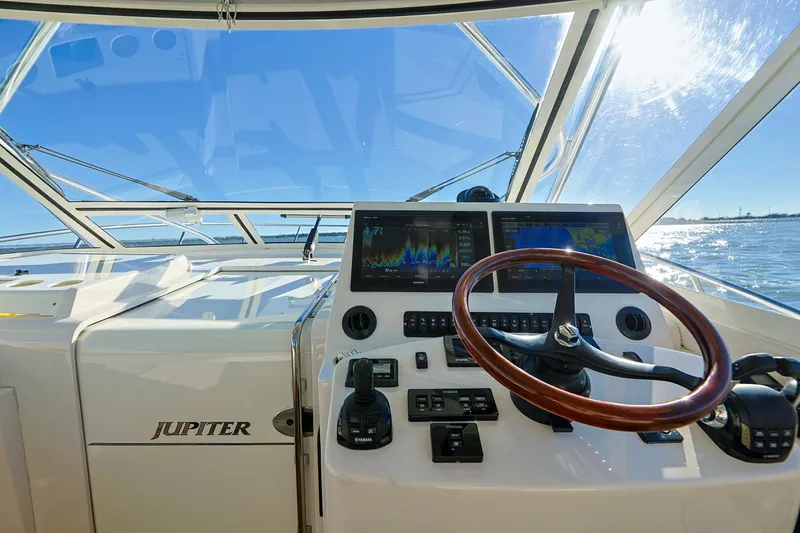 Tranquila Yacht Photos Pics Jupiter 41 EX 2016 boat helm with navigation screens and wooden steering wheel.