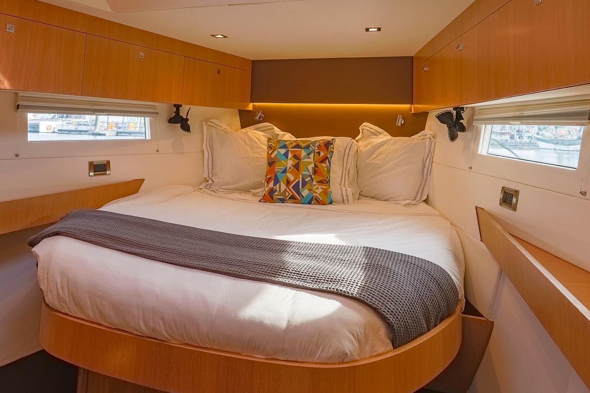 Luxurious cabin interior of 2018 Amel 55 yacht with cozy bed and modern decor.