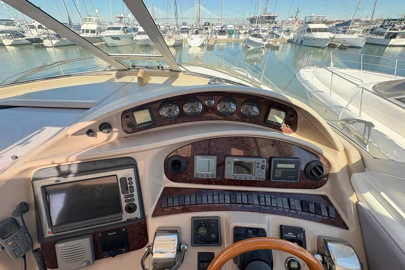Andiamo II Yacht Photos Pics 2002 Sea Ray 480 Motor Yacht helm with navigation instruments, overlooking marina.