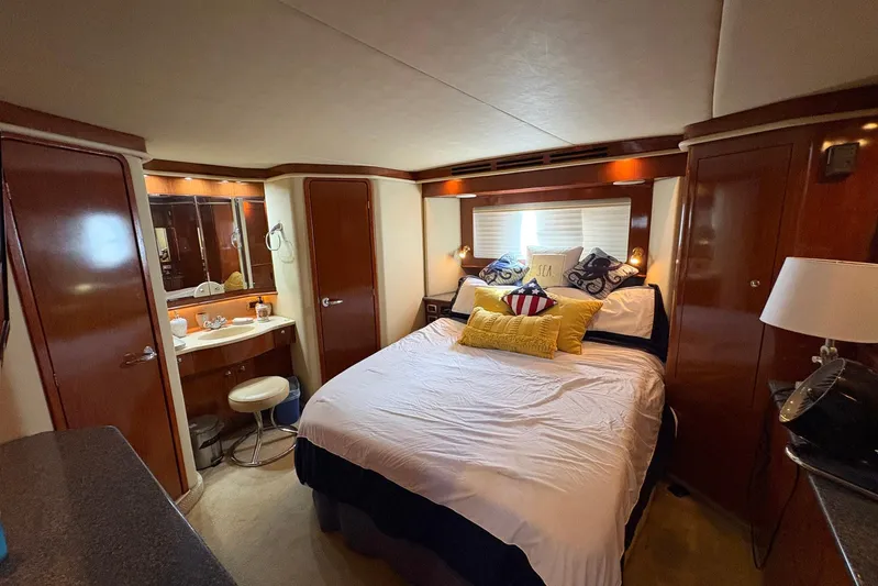 Andiamo II Yacht Photos Pics Luxurious 2002 Sea Ray 480 Motor Yacht bedroom with elegant wood finishes and cozy bedding.
