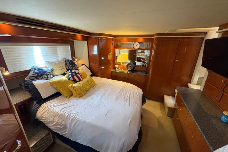 Andiamo II Yacht Photos Pics Luxurious bedroom interior of 2002 Sea Ray 480 Motor Yacht with elegant wood finishes.