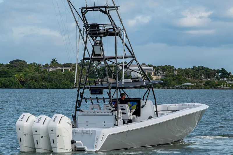  Yacht Photos Pics 2024 Contender 44 ST boat with triple engines cruising on a scenic waterway.