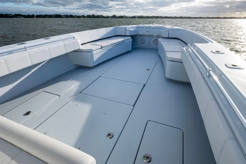  Yacht Photos Pics 2024 Contender 44 ST boat deck with spacious seating and storage, on calm waters.