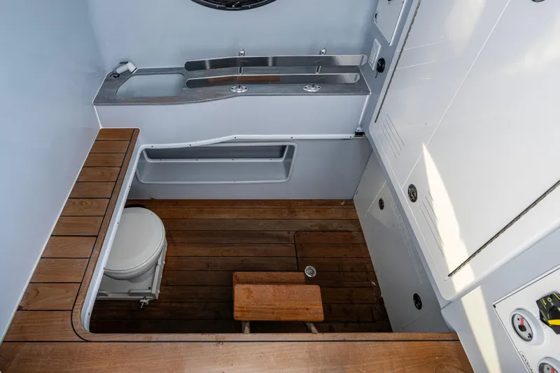  Yacht Photos Pics 2024 Contender 44 ST boat interior with wooden flooring and compact bathroom amenities.
