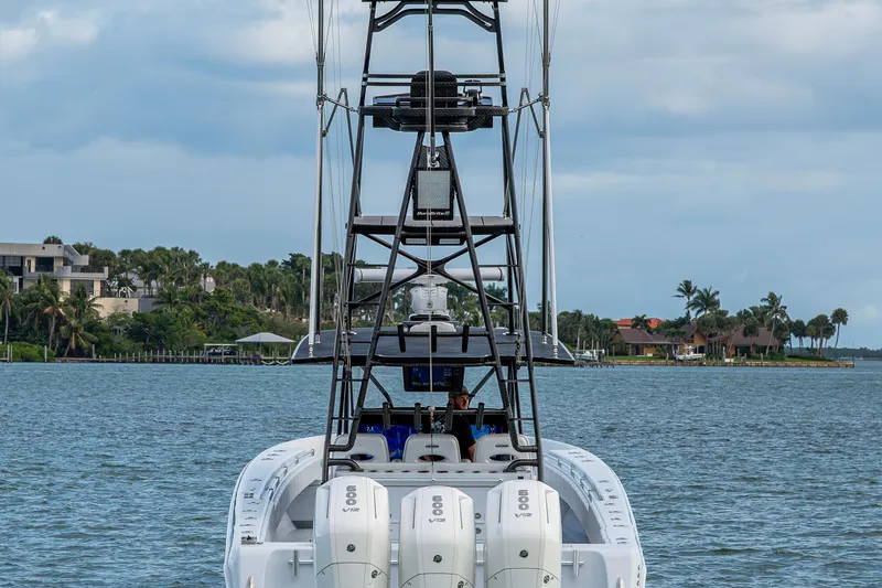  Yacht Photos Pics 2024 Contender 44 ST boat with triple engines on a scenic waterway.