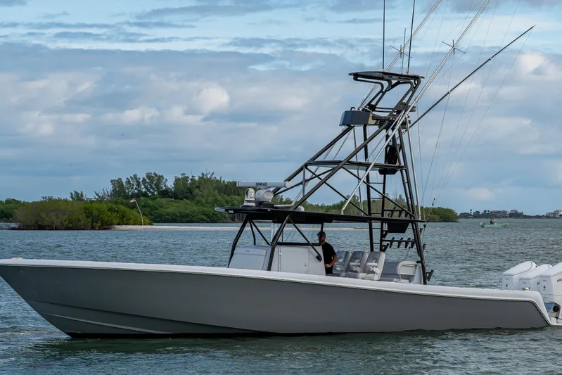  Yacht Photos Pics 2024 Contender 44 ST boat on water, featuring sleek design and advanced fishing tower.