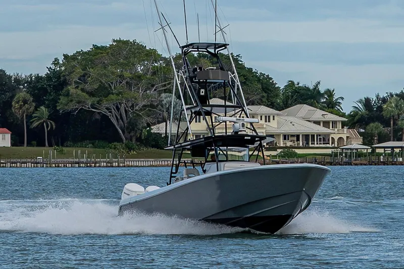  Yacht Photos Pics 2024 Contender 44 ST boat cruising on water near luxury waterfront homes.