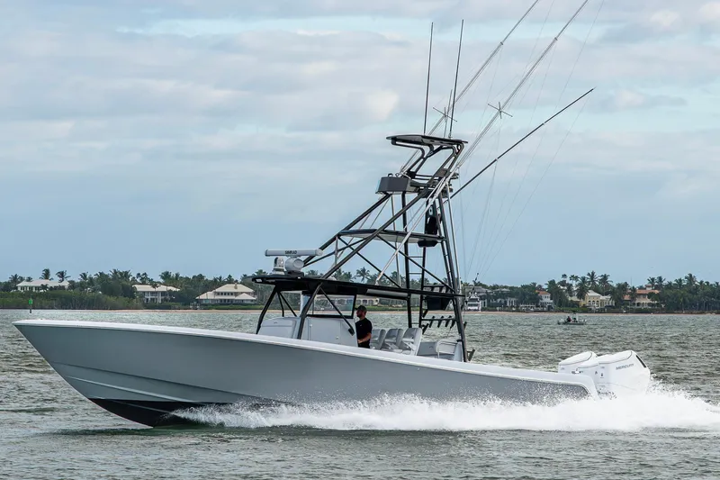  Yacht Photos Pics 2024 Contender 44 ST boat cruising on water with scenic coastal background.