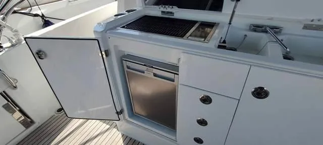  Yacht Photos Pics 2019 Jeanneau Cap Camarat 10.5 WA boat kitchen with open cabinet and stainless steel appliances.
