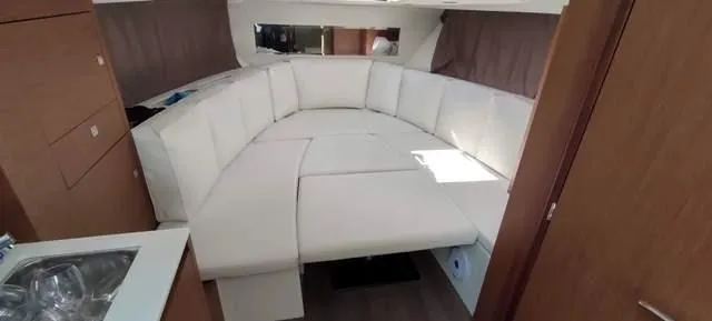  Yacht Photos Pics Interior of 2019 Jeanneau Cap Camarat 10.5 WA with white seating and wood accents.