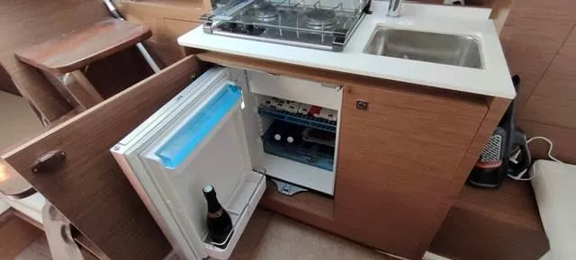  Yacht Photos Pics Compact kitchen area in a 2019 Jeanneau Cap Camarat 10.5 WA boat with fridge and sink.