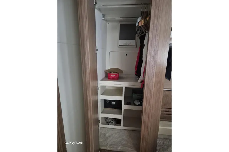  Yacht Photos Pics Open closet on Absolute 52 FLY yacht, featuring shelves and hanging space, 2018 model.