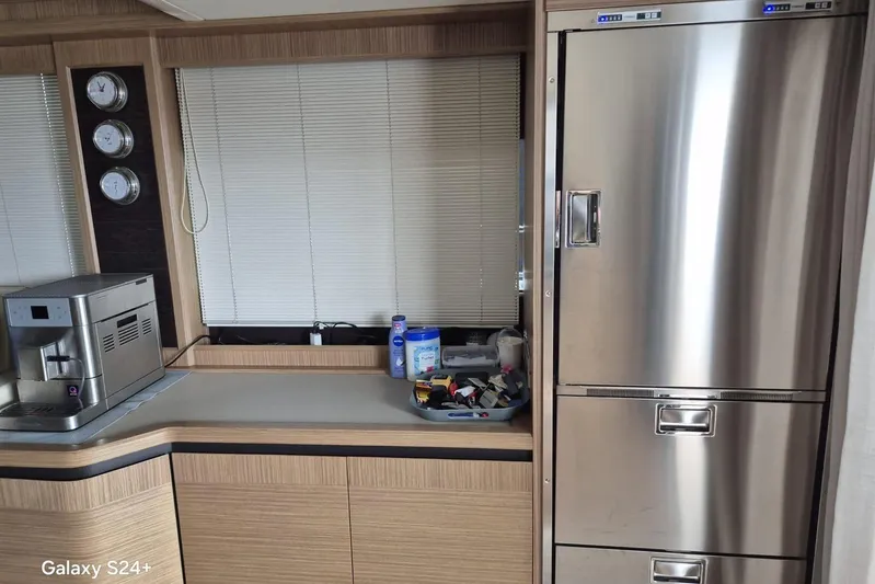  Yacht Photos Pics Modern yacht kitchen with stainless steel appliances, coffee machine, and storage on Absolute 52 FLY, 2018.
