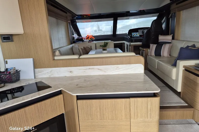  Yacht Photos Pics Luxurious interior of 2018 Absolute 52 FLY yacht with modern kitchen and seating area.