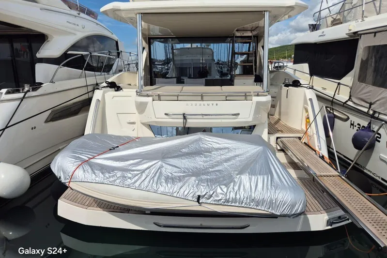  Yacht Photos Pics Luxury Absolute 52 FLY yacht, 2018 model, docked with covered equipment on deck.
