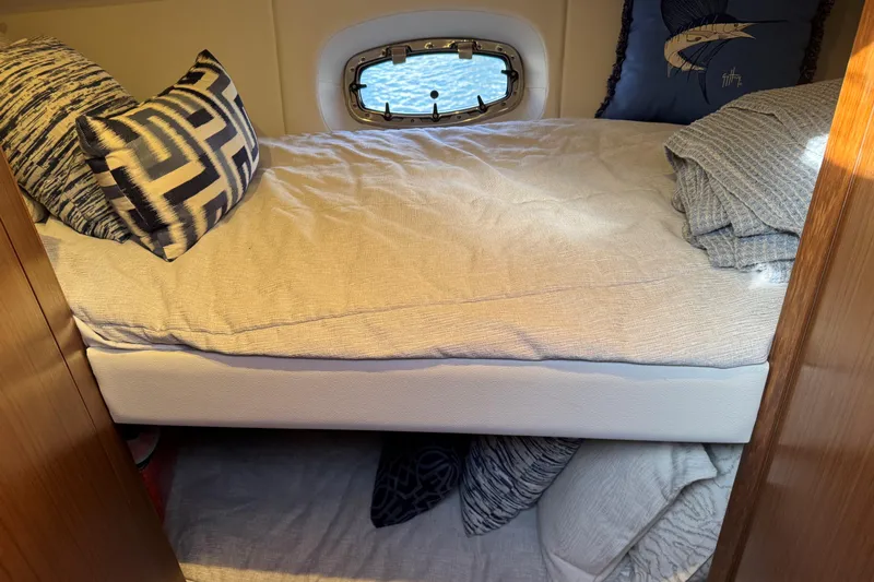  Yacht Photos Pics Cozy cabin interior of 2022 Tiara Yachts 43 Open with stylish bedding and porthole.