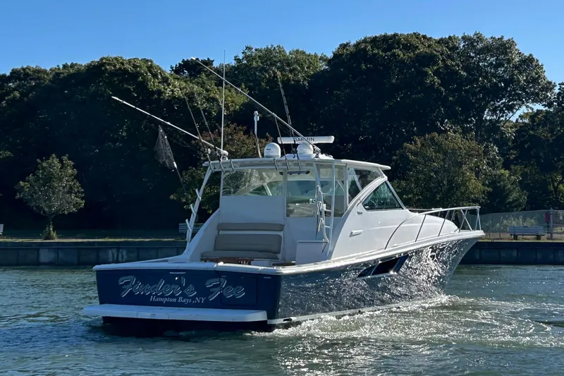  Yacht Photos Pics 2022 Tiara Yachts 43 Open cruising on a sunny day near lush greenery.