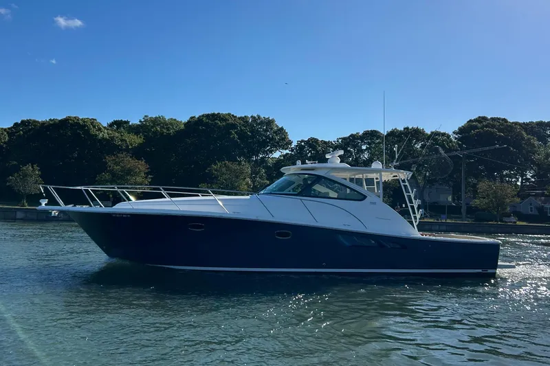  Yacht Photos Pics 2022 Tiara Yachts 43 Open cruising on a sunny day, surrounded by trees.