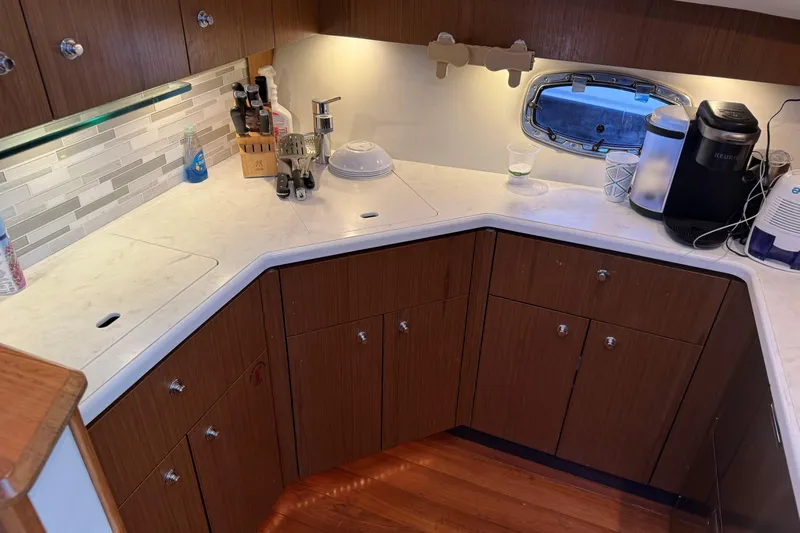  Yacht Photos Pics Modern kitchen in 2022 Tiara Yachts 43 Open, featuring wood cabinets and sleek countertops.