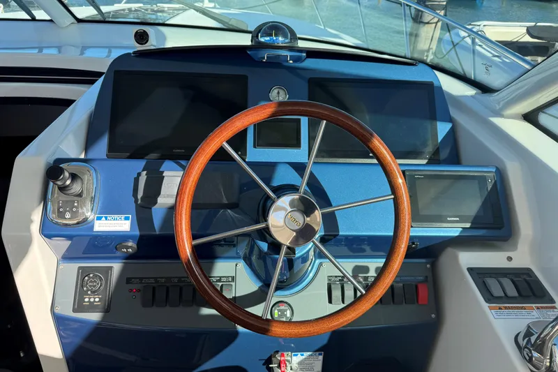 Yacht Photos Pics Helm of 2022 Tiara Yachts 43 Open with wooden steering wheel and modern controls.