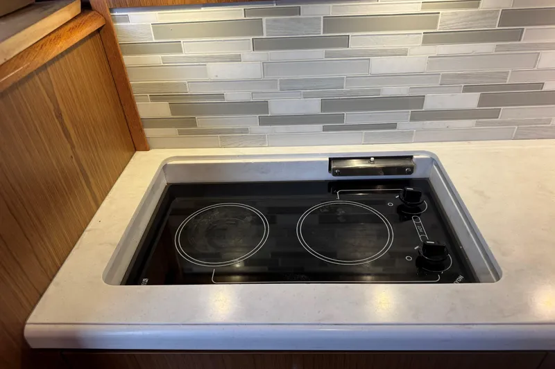  Yacht Photos Pics Modern kitchen cooktop on 2022 Tiara Yachts 43 Open, featuring sleek design and backsplash.