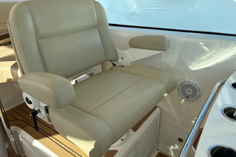  Yacht Photos Pics Luxury helm seat on 2022 Tiara Yachts 43 Open, featuring beige leather and armrests.