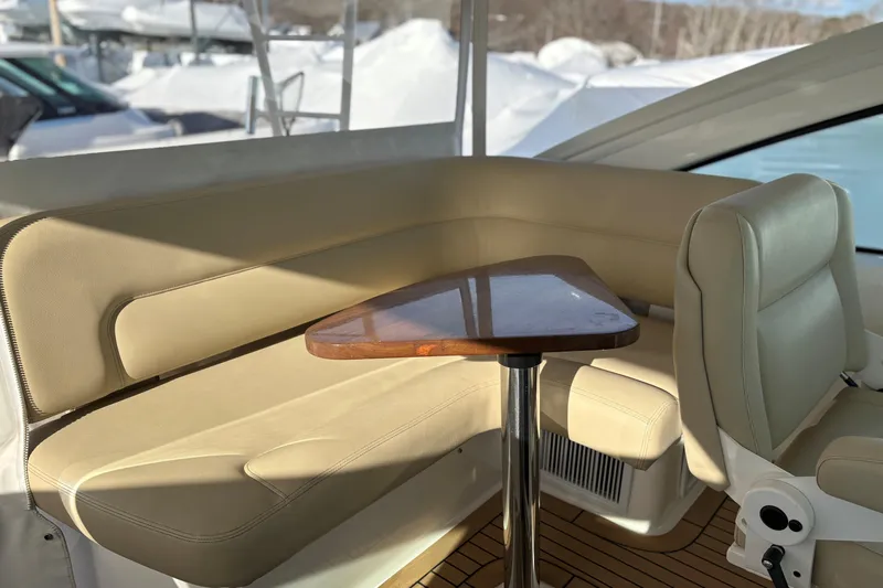  Yacht Photos Pics Luxurious seating area on 2022 Tiara Yachts 43 Open, featuring beige upholstery and wooden table.