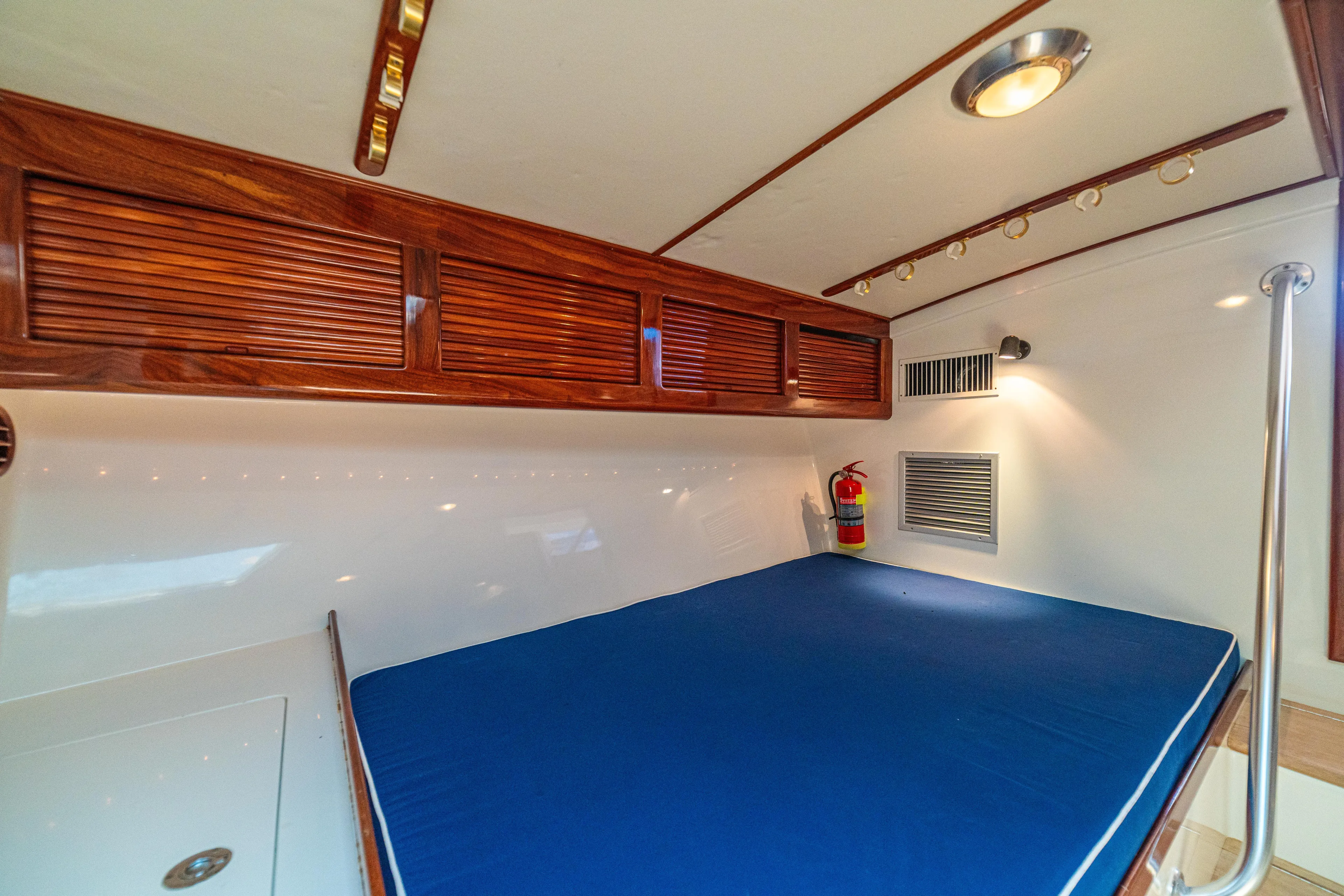 Pez Collector Yacht Photos Pics Interior cabin of 2010 Custom Marcam 43 Convertible with blue bedding and wooden storage cabinets.