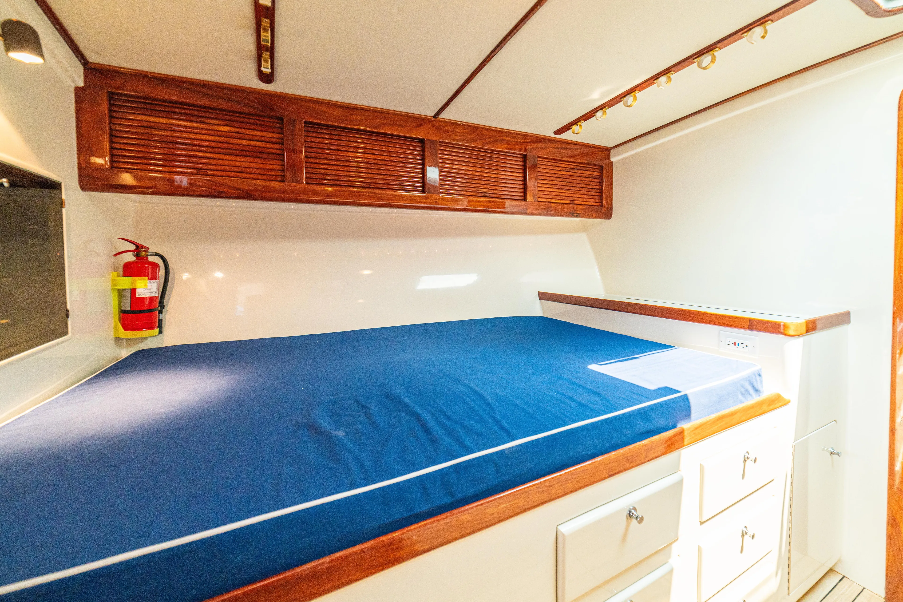 Pez Collector Yacht Photos Pics Interior cabin of 2010 Custom Marcam 43 Convertible with blue bedding and wooden storage cabinets.