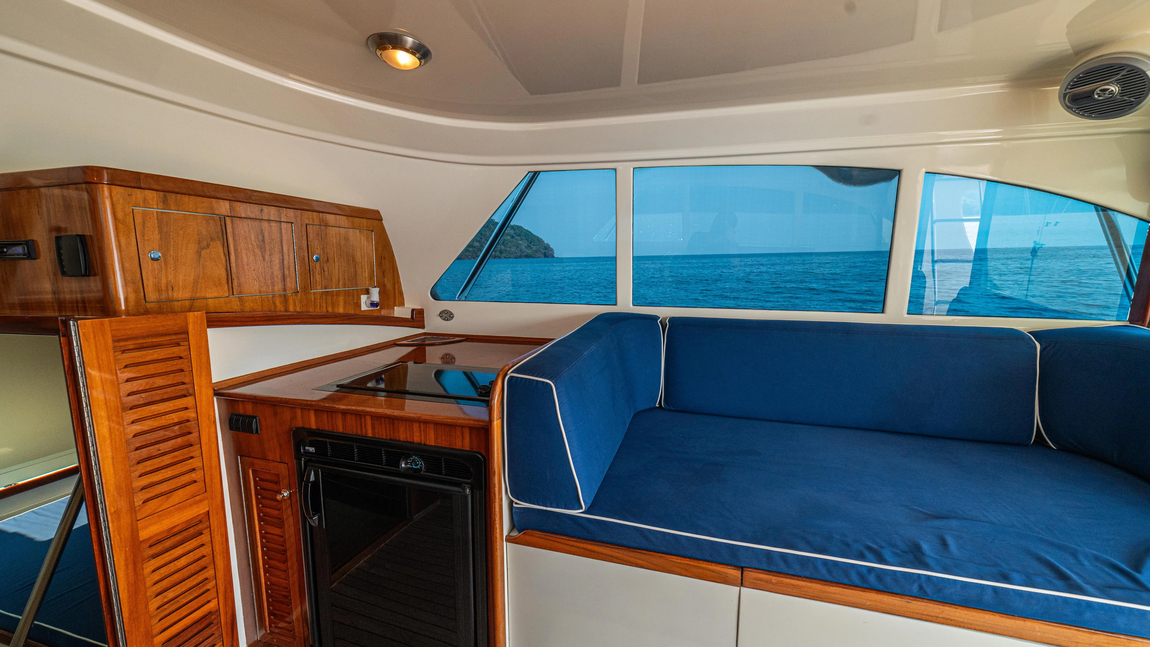 Pez Collector Yacht Photos Pics Interior of 2010 Custom Marcam 43 Convertible yacht with blue seating and wooden cabinetry.