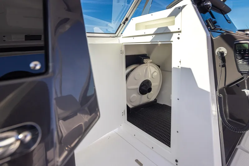  Yacht Photos Pics 2021 Blackfin 252DC boat interior storage compartment with coiled hose.