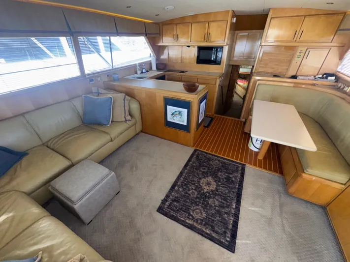 Hear After Yacht Photos Pics Interior of a 1995 Bertram 50 Convertible yacht with cozy seating and modern kitchen.