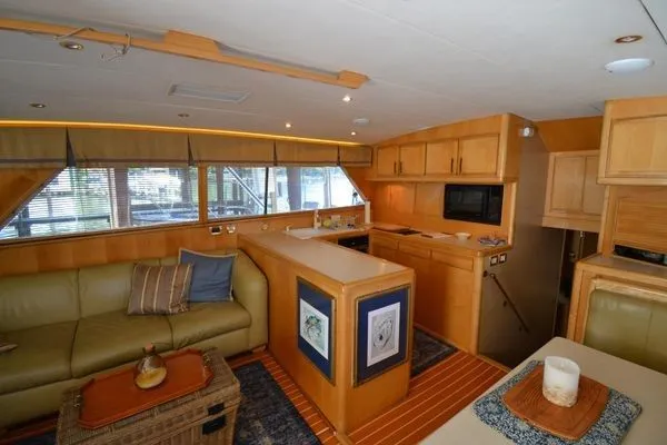 Hear After Yacht Photos Pics Interior of a 1995 Bertram 50 Convertible yacht with modern kitchen and cozy seating area.