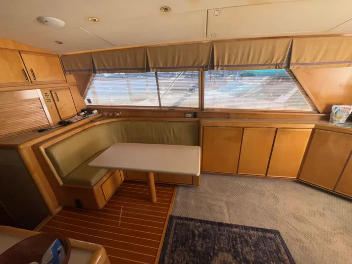 Hear After Yacht Photos Pics Interior of a 1995 Bertram 50 Convertible yacht with wood cabinetry and dining area.