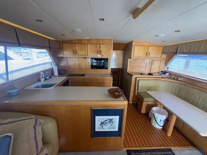 Hear After Yacht Photos Pics Interior of a 1995 Bertram 50 Convertible yacht with kitchen and dining area.