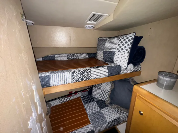 Hear After Yacht Photos Pics Interior of 1995 Bertram 50 Convertible with bunk beds and patterned bedding.