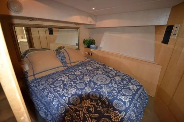 Hear After Yacht Photos Pics Cozy bedroom in 1995 Bertram 50 Convertible yacht with floral bedding and wood accents.