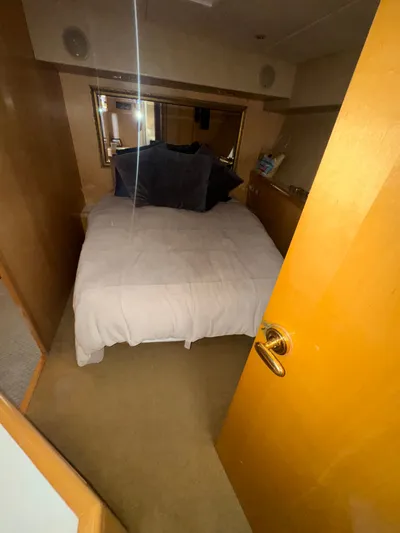 Hear After Yacht Photos Pics Cozy bedroom in 1995 Bertram 50 Convertible yacht with plush bedding and wooden accents.