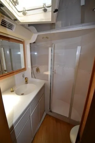 Hear After Yacht Photos Pics Bathroom interior of a 1995 Bertram 50 Convertible yacht with shower and vanity.