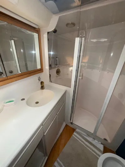 Hear After Yacht Photos Pics Bathroom interior of 1995 Bertram 50 Convertible yacht with shower and sink.