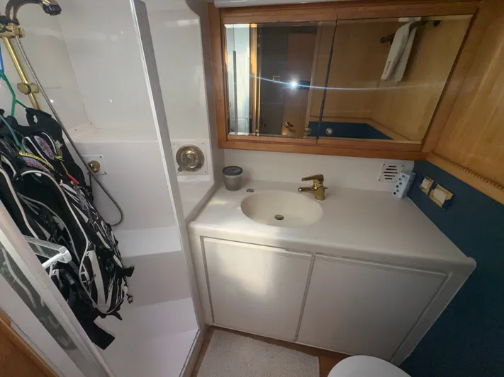 Hear After Yacht Photos Pics Bathroom interior of a 1995 Bertram 50 Convertible yacht with sink and shower.