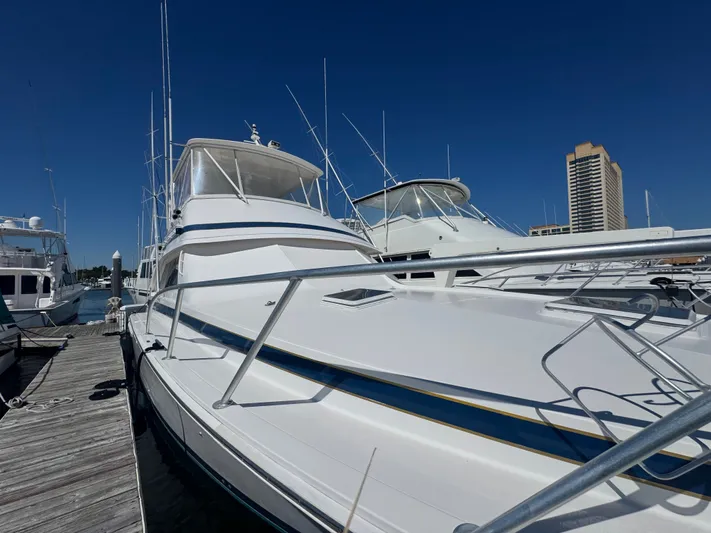 Hear After Yacht Photos Pics 1995 Bertram 50 Convertible yacht docked at marina under clear blue sky.