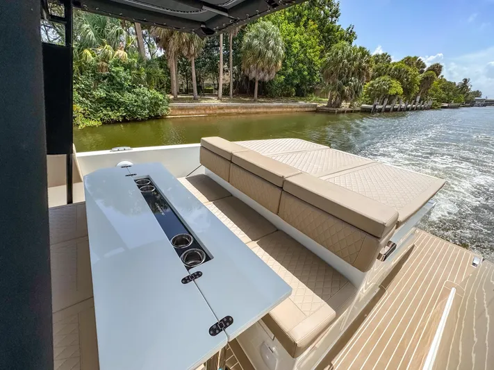  Yacht Photos Pics 2024 De Antonio Yachts D28 Open, luxurious seating and table, cruising on a scenic waterway.