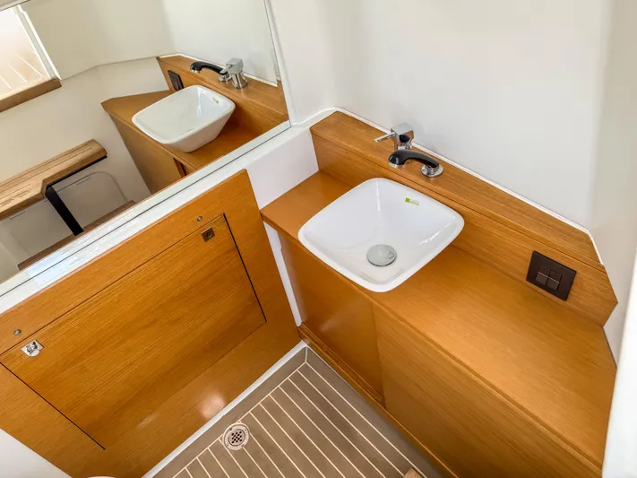  Yacht Photos Pics 2024 De Antonio Yachts D28 Open bathroom with wooden cabinetry and modern sink.