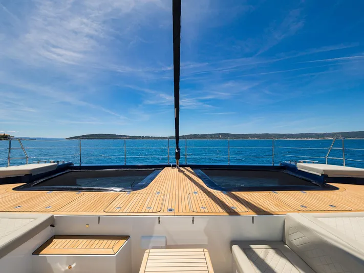 Dessus Yacht Photos Pics Luxurious Sunreef 60 yacht deck with dual hot tubs, overlooking serene ocean view, 2022 model.