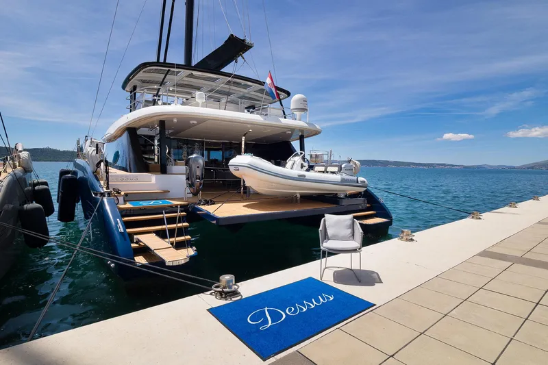 Dessus Yacht Photos Pics Luxury Sunreef 60 yacht docked at marina, 2022 model, with tender boat on deck.