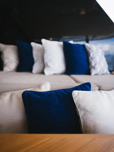 Dessus Yacht Photos Pics Luxurious interior of 2022 Sunreef 60 yacht with elegant blue and white cushions.