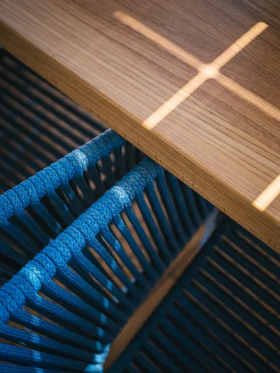 Dessus Yacht Photos Pics Close-up of Sunreef 60 yacht's wooden table and blue rope chair, 2022 model.