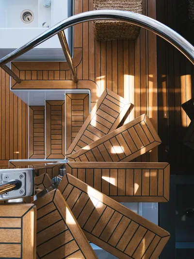 Dessus Yacht Photos Pics Wooden spiral staircase on 2022 Sunreef 60 yacht, showcasing elegant design and craftsmanship.